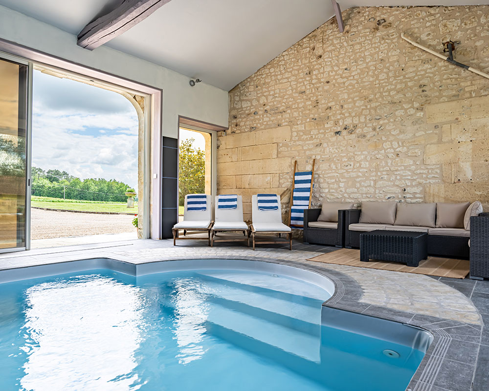 Large blue swimming pool inside limestone building