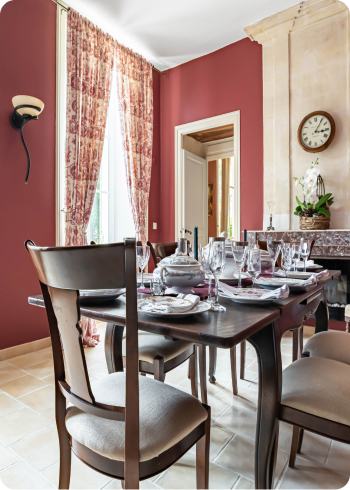 Classic french style dining room with red wall paper and oak furniture and french windows