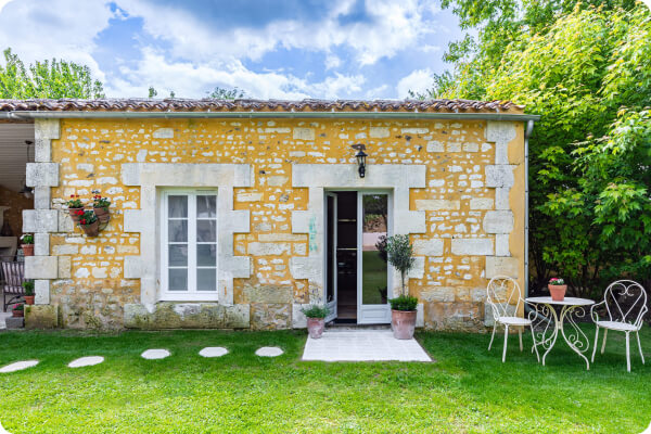 Small outbuilding with limestone wall in the sun