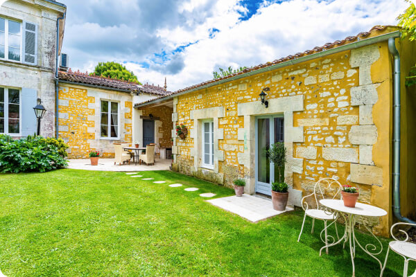 Small outbuilding with large windows and limestone wall